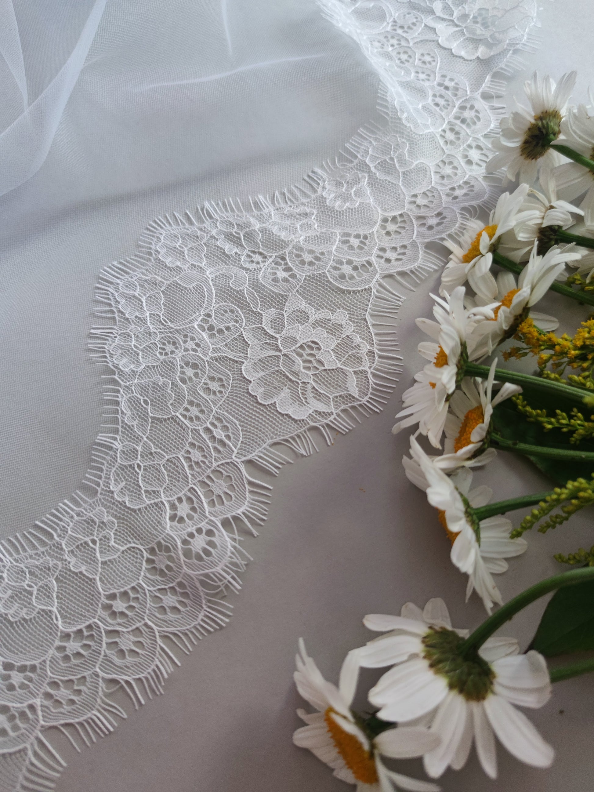 Delicate Chantilly lace mantilla veil in light ivory with floral accents.