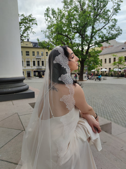 The Laima single-tier Chantilly lace mantilla veil in light ivory with scalloped floral lace edge, bride back view