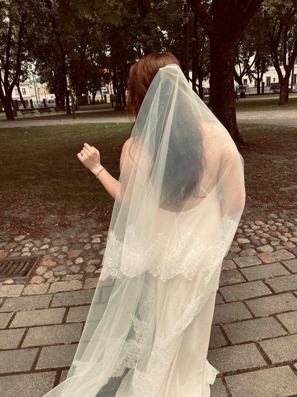 Bride wearing two-tier ivory blusher veil, both layers trimmed with hand-sewn French Chantilly lace, cathedral length