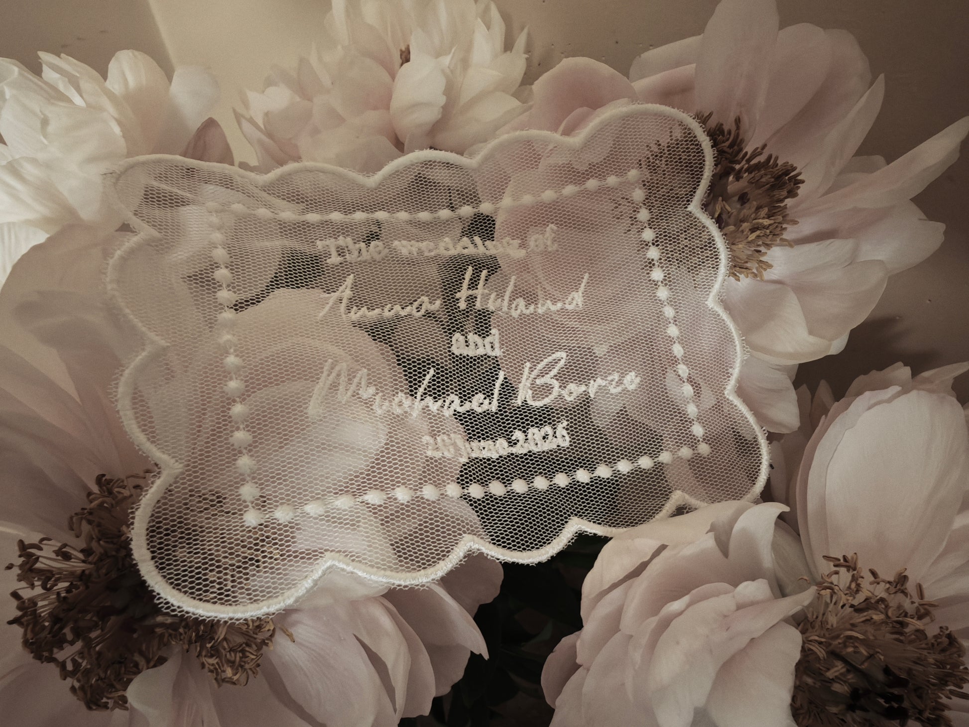 Personalized embroidered tulle wedding invitation, ivory, close-up of embroidery detail