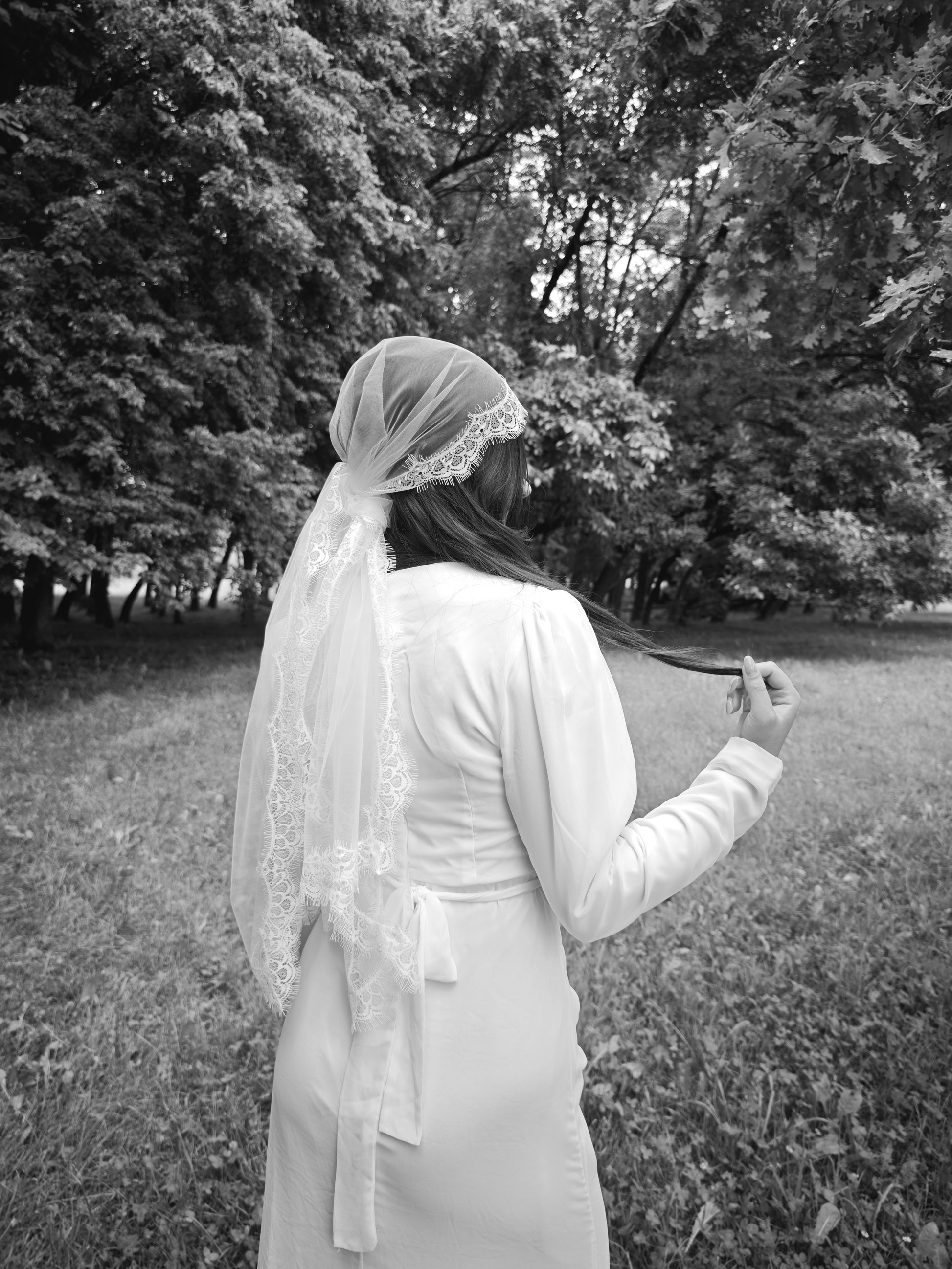 Side view of the Chantilly lace kerchief veil tied bandana style in ivory
