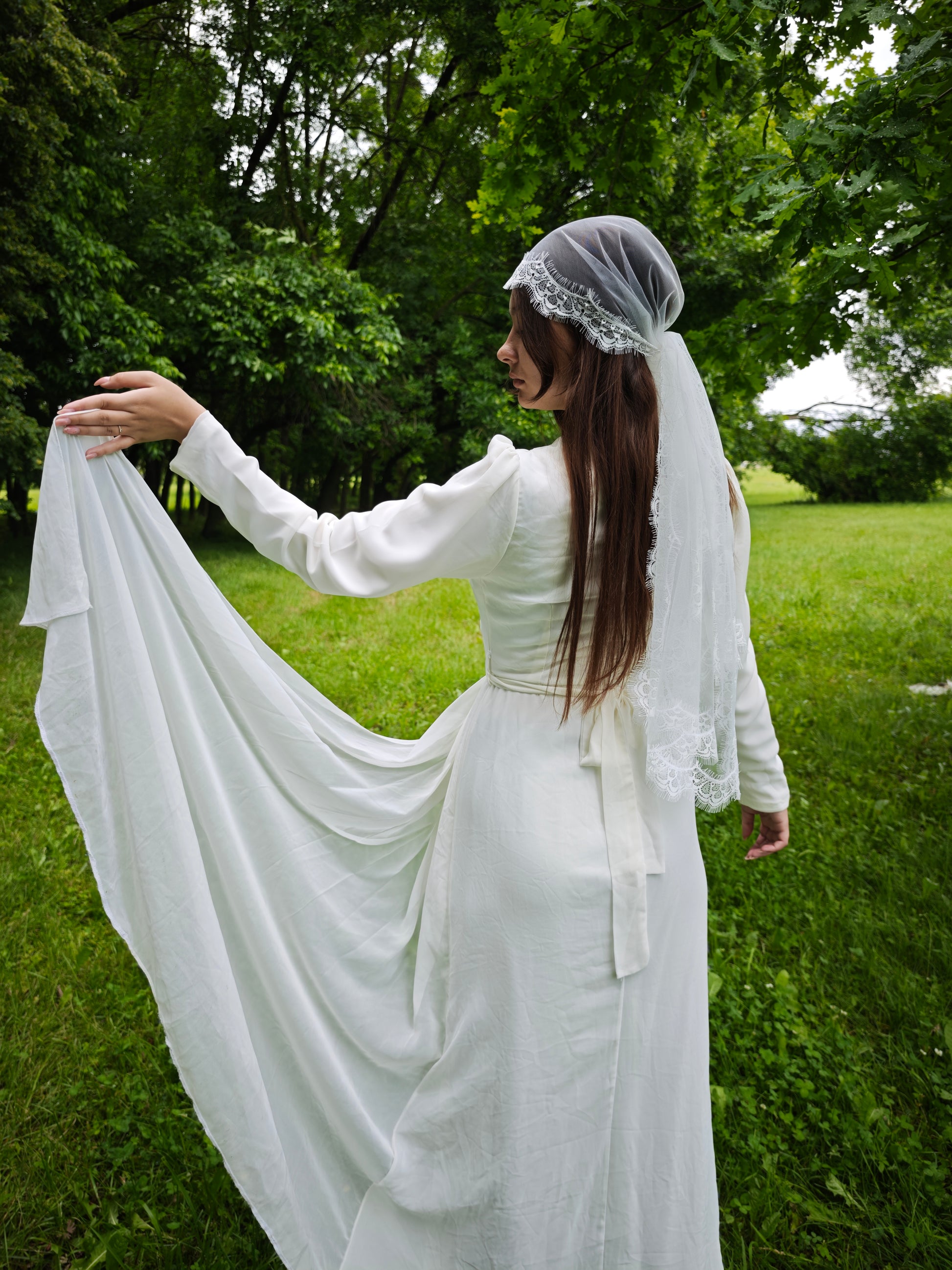 Lace kerchief veil in ivory tulle with delicate Chantilly lace trim framing the bride