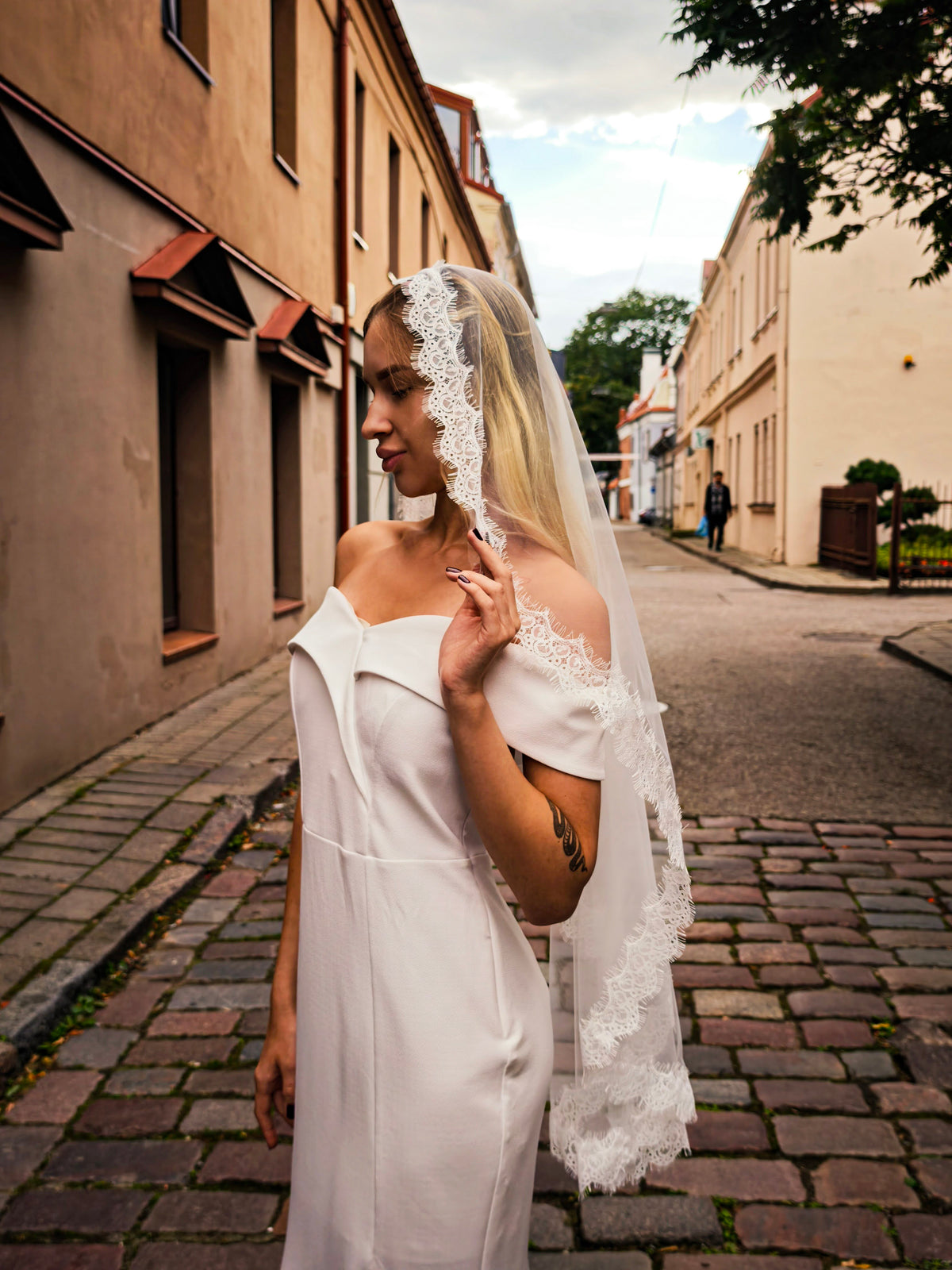 Profile of a bride in a Chantilly lace veil, narrow lace edge of the Rocío mantilla veil along the face